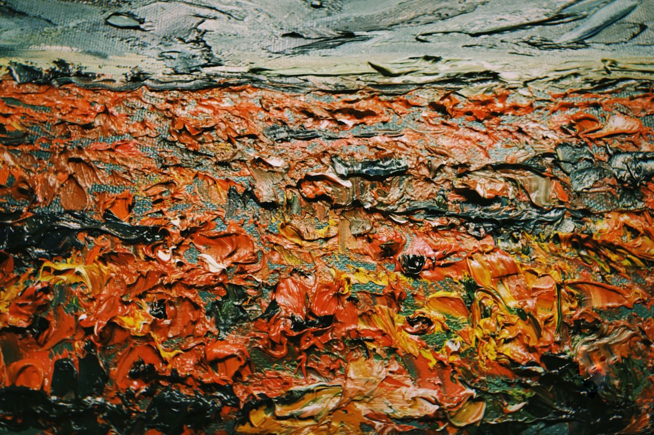Close-up of a vibrant abstract painting with rich textures and colors, showcasing thickly applied oil paints.